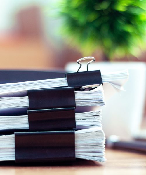 Stack of documents placed on a business desk in a business office.